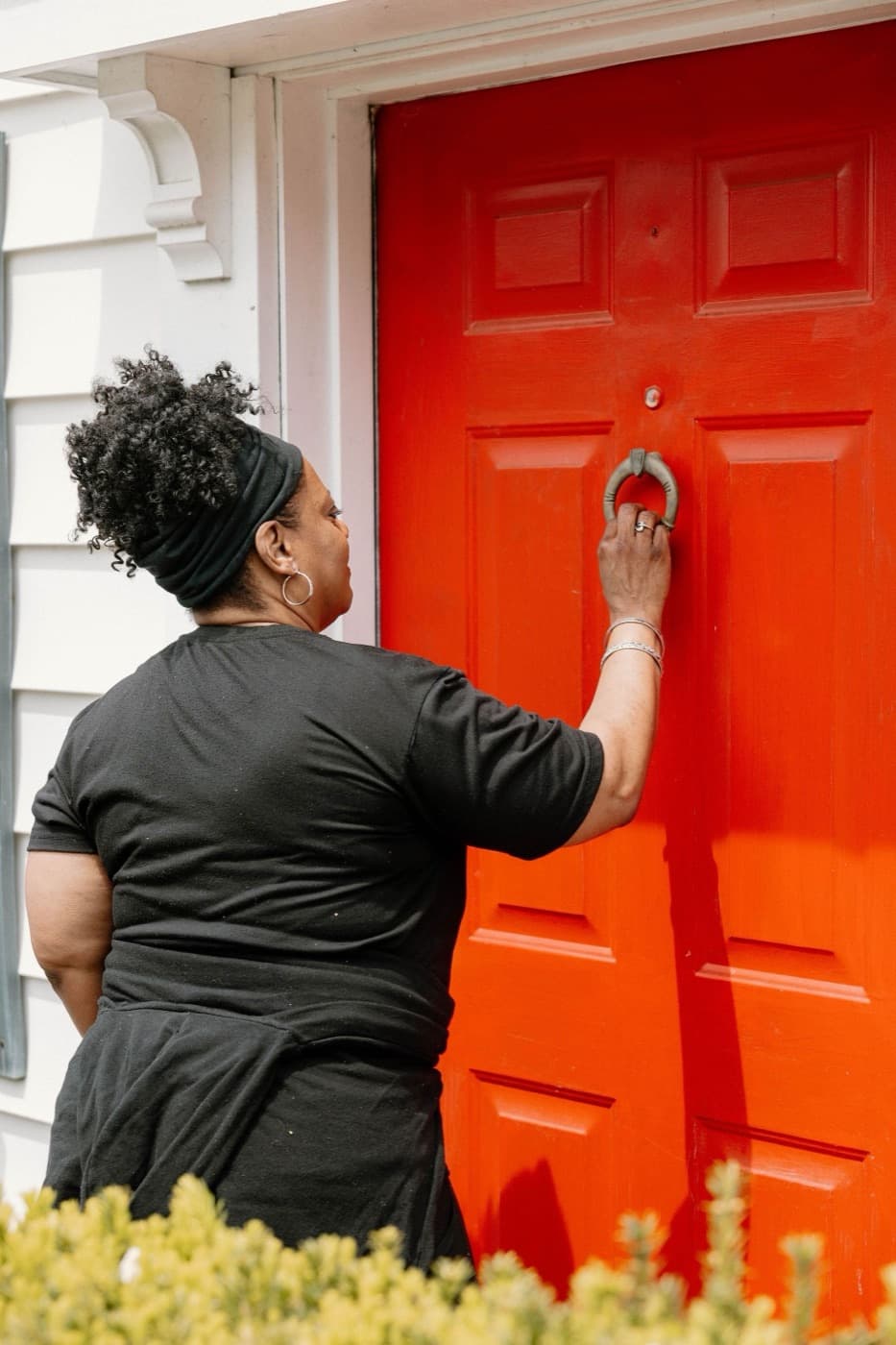 She Does Hauling founder in a branded tee knocking on a customer's front door