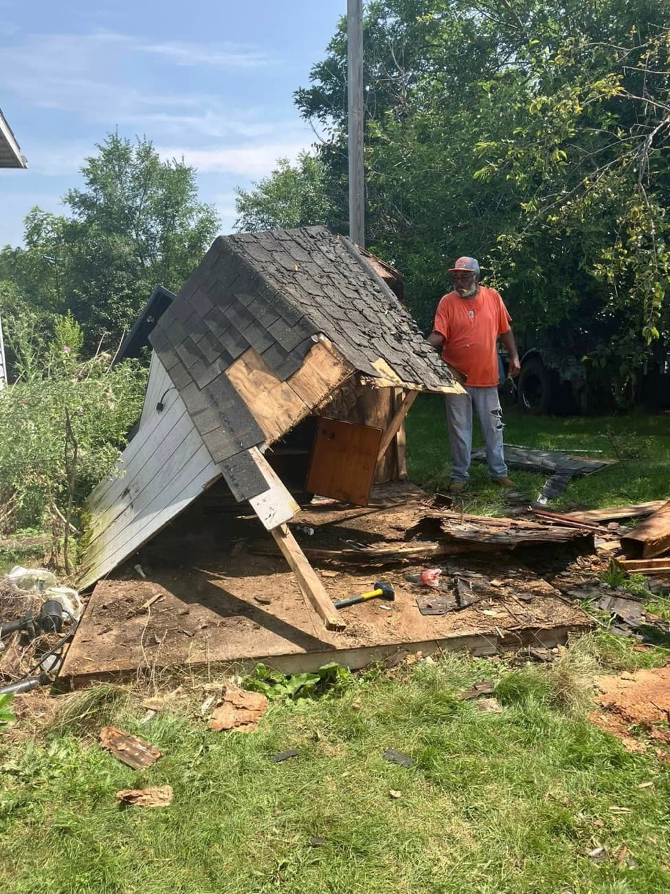 She Does Hauling crew member demolishing a collapsed shed with a sledgehammer